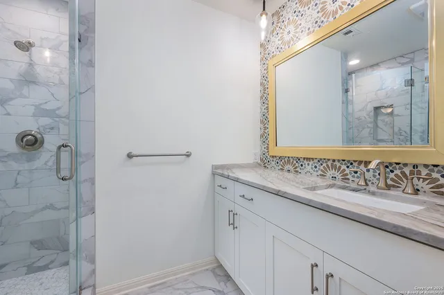 a bathroom with a granite countertop sink and a mirror