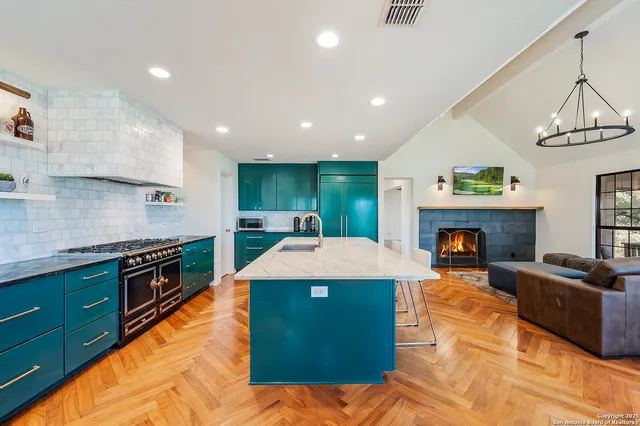 a kitchen with stainless steel appliances granite countertop a sink a stove top oven a counter space and cabinets