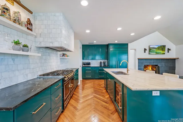 a kitchen with kitchen island stainless steel appliances a sink stove and cabinets