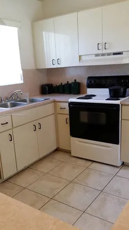 a kitchen with stainless steel appliances granite countertop a stove a sink and a white cabinets