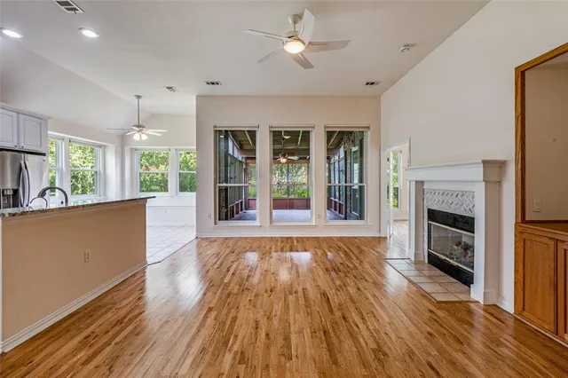 wooden floor fireplace and windows in an empty room