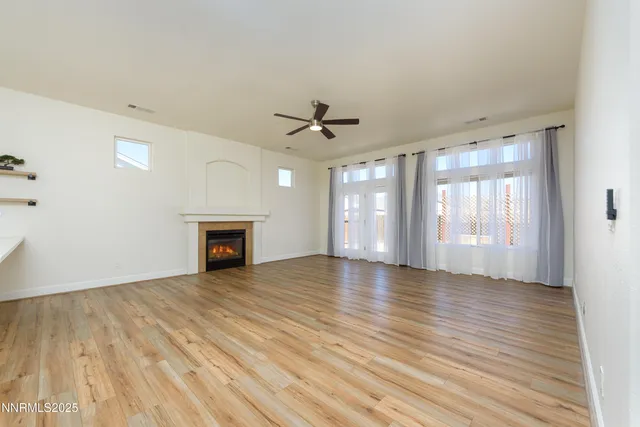 a view of an empty room with a window and a kitchen