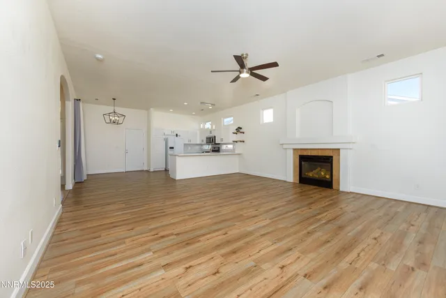 a view of empty room with wooden floor and fireplace