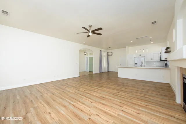 a view of a kitchen with kitchen island wooden floor and a ceiling fan