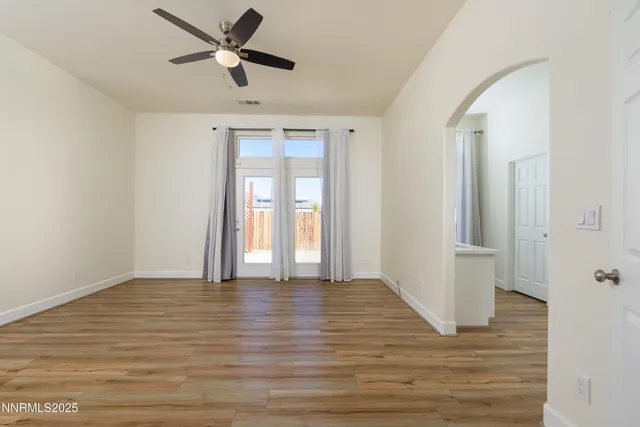 a view of an empty room with window and wooden floor