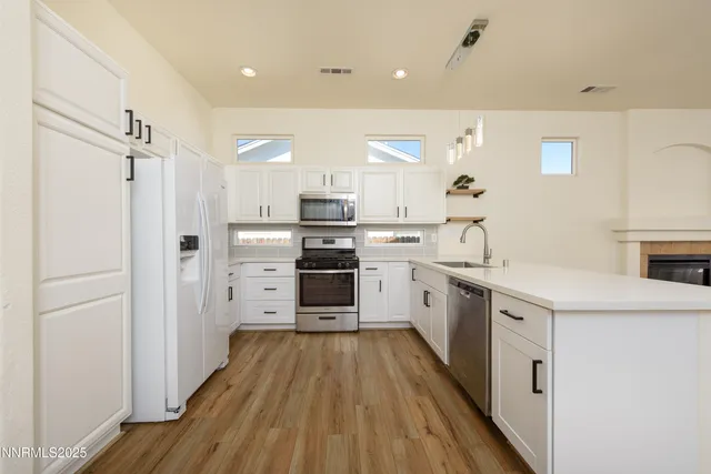 a kitchen with cabinets and wooden floor