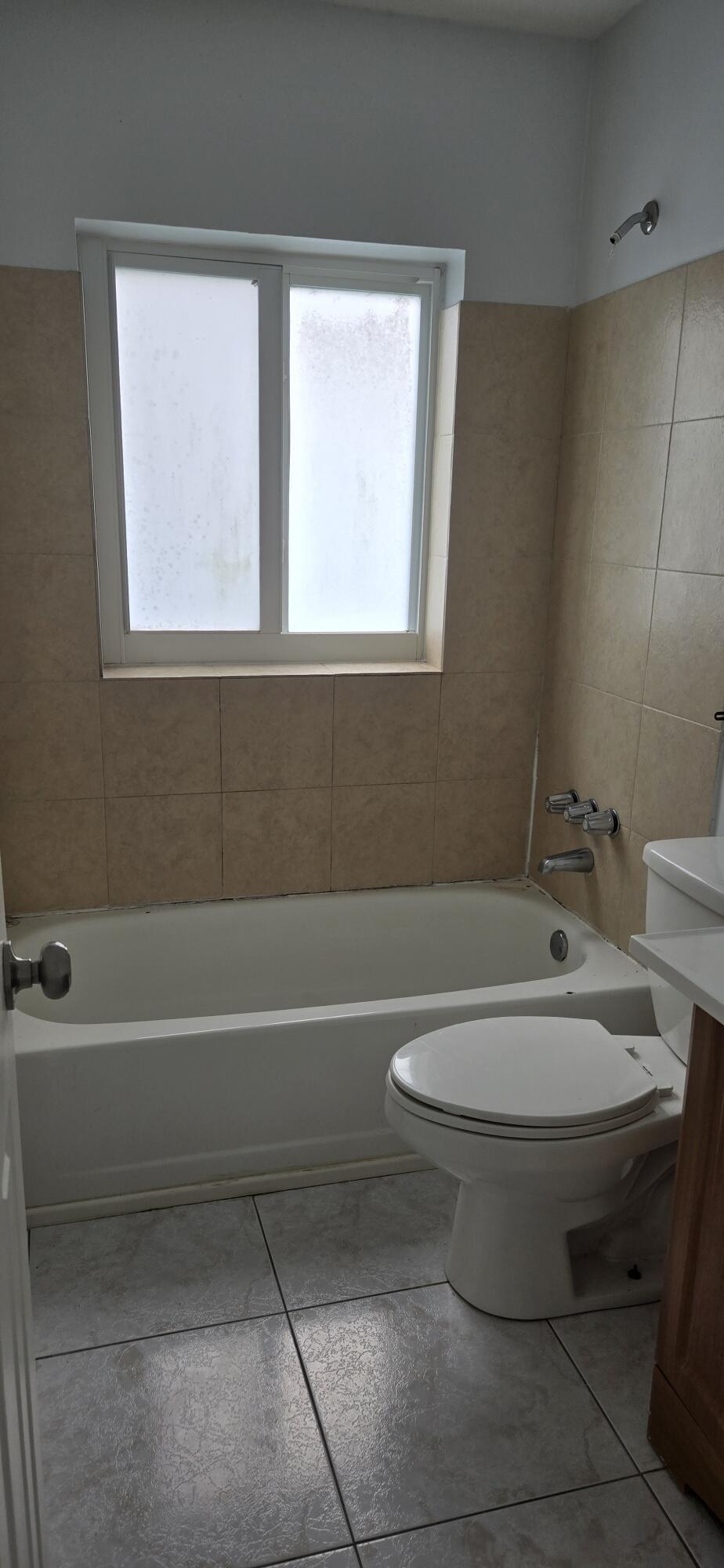 6158 Westfall Road Lake Worth, FL 33463 - Photo 12 of 24 a bathroom with a toilet a sink and bathtub