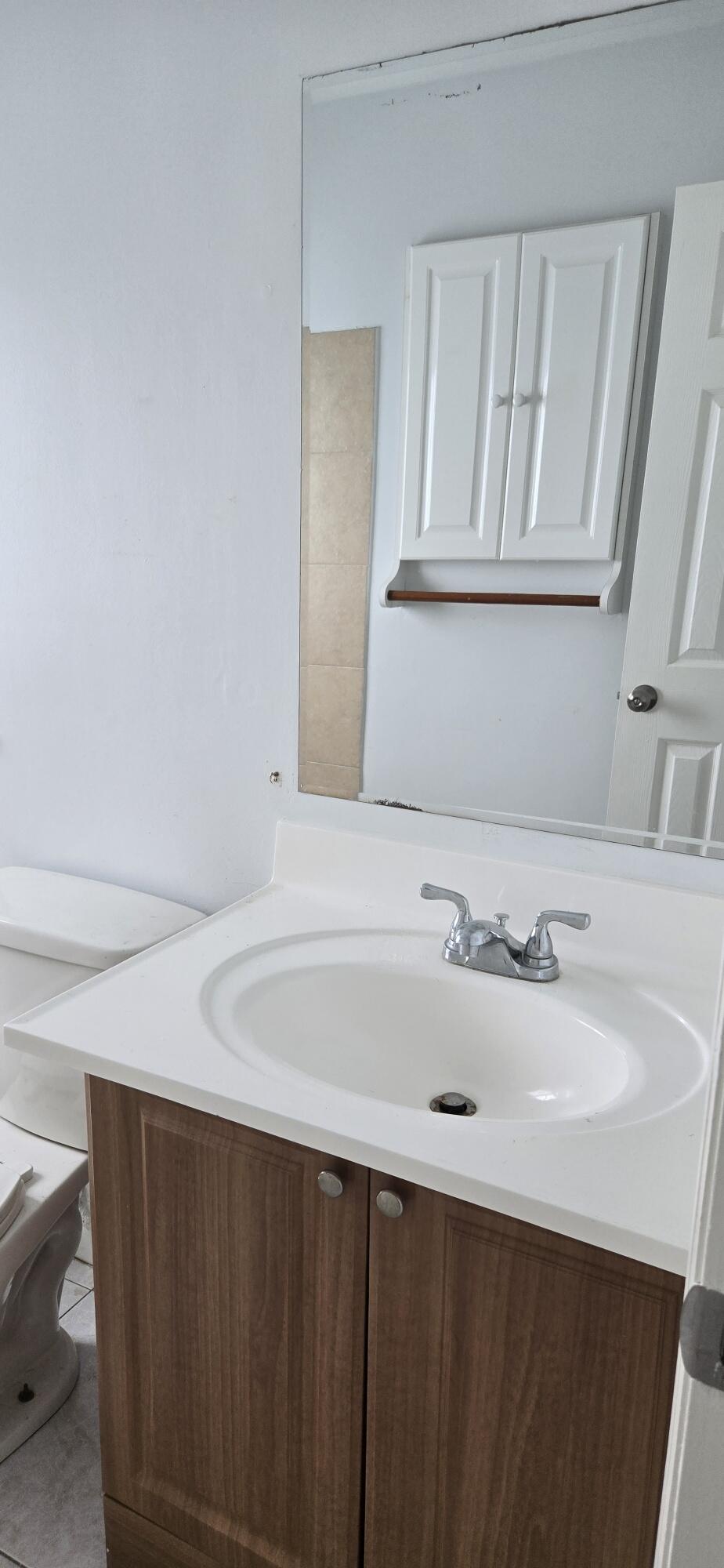 6158 Westfall Road Lake Worth, FL 33463 - Photo 13 of 24 a bathroom with a sink and a mirror