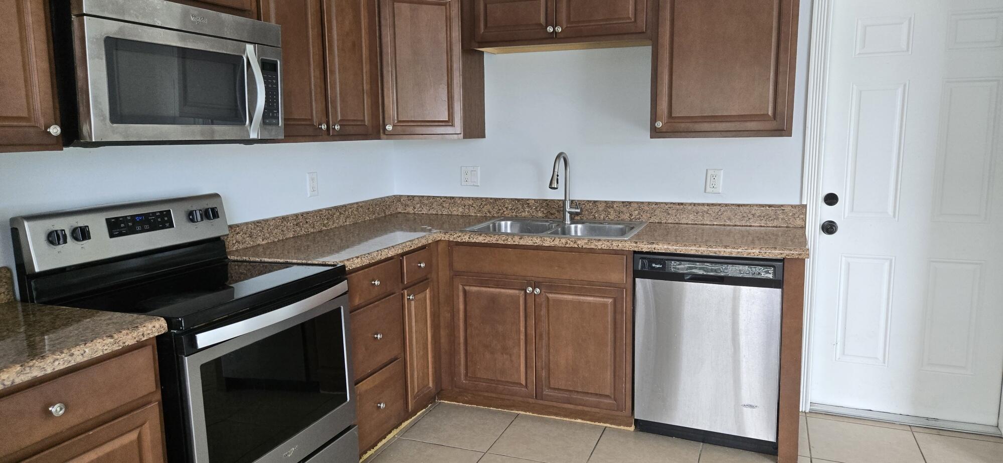 6158 Westfall Road Lake Worth, FL 33463 - Photo 4 of 24 a kitchen with granite countertop cabinets stove and microwave