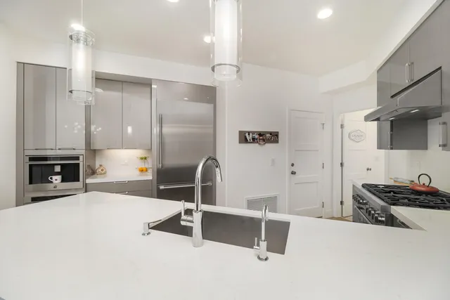 a kitchen with stainless steel appliances a sink stove and refrigerator