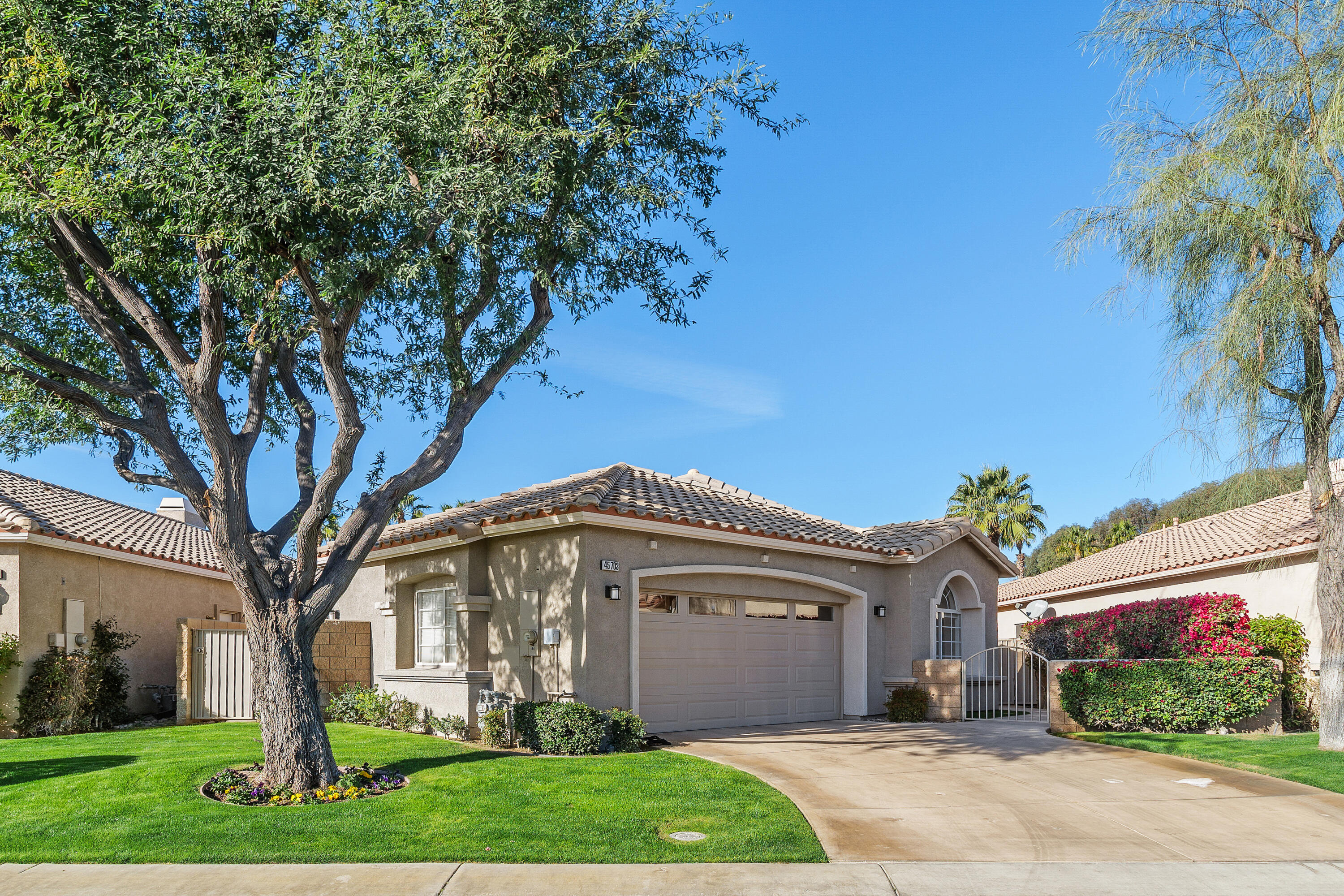 45703 Crosswater Street Indio, CA 92201 - Photo 3 of 41 a front view of a house with a garden and plants