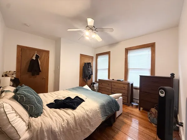 a bedroom with a bed and wooden floor