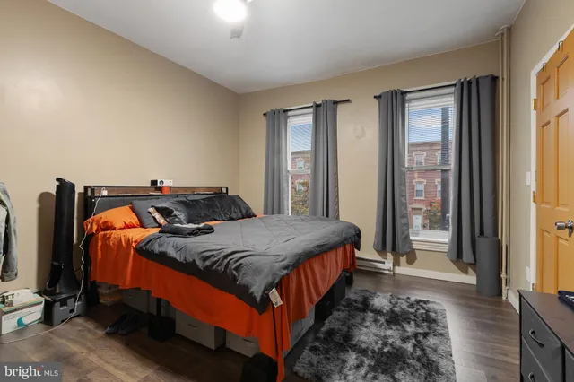 a bedroom with a large bed and a flat tv screen on a dresser