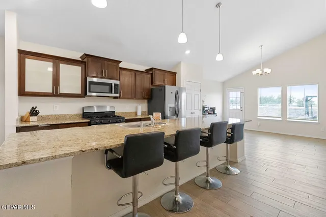 a kitchen with stainless steel appliances a stove a sink a microwave a refrigerator and cabinets