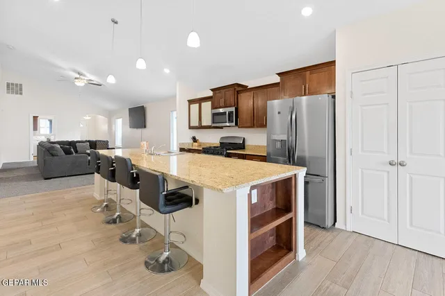 a kitchen with kitchen island a counter top space stainless steel appliances and a counter top space