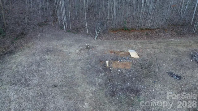 a view of a dry yard with wooden fence