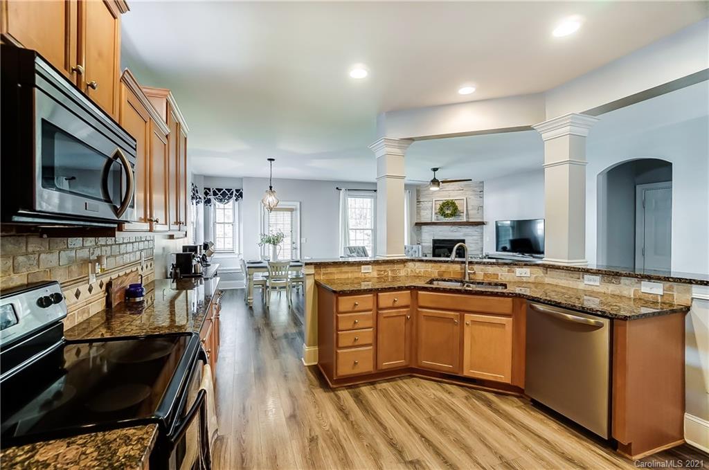 3284 Richard's Crossing Fort Mill, SC 29708 - Photo 15 of 43 a kitchen with stainless steel appliances granite countertop a stove top oven a sink dishwasher and white cabinets with wooden floor