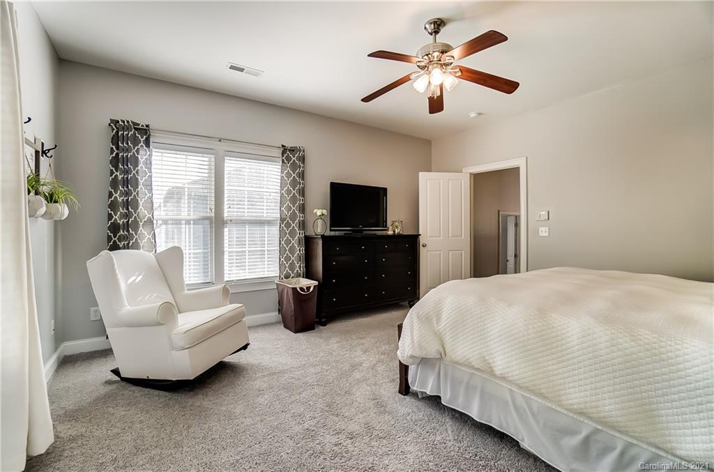 3284 Richard's Crossing Fort Mill, SC 29708 - Photo 26 of 43 a spacious bedroom with a bed a couch and a chandelier