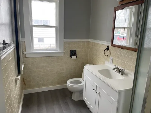 a bathroom with a sink toilet and a window