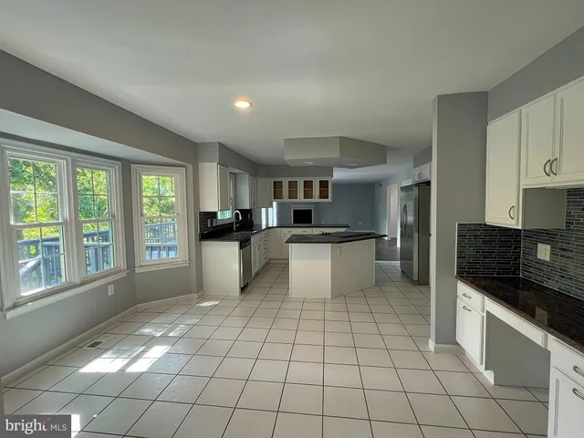 a large white kitchen with a stove a sink dishwasher and a refrigerator