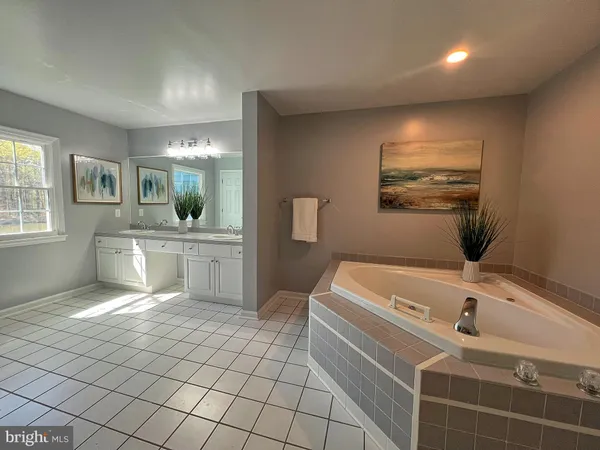 a bathroom with a bathtub sink and mirror