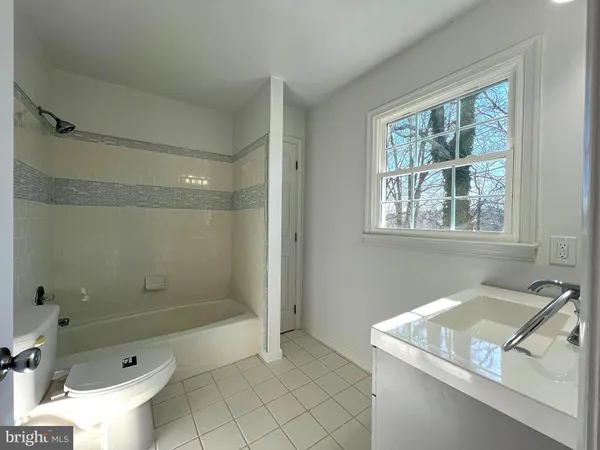 a bathroom with a granite countertop sink a toilet and shower