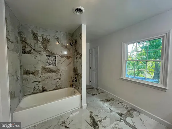 a bathroom with a bathtub and shower