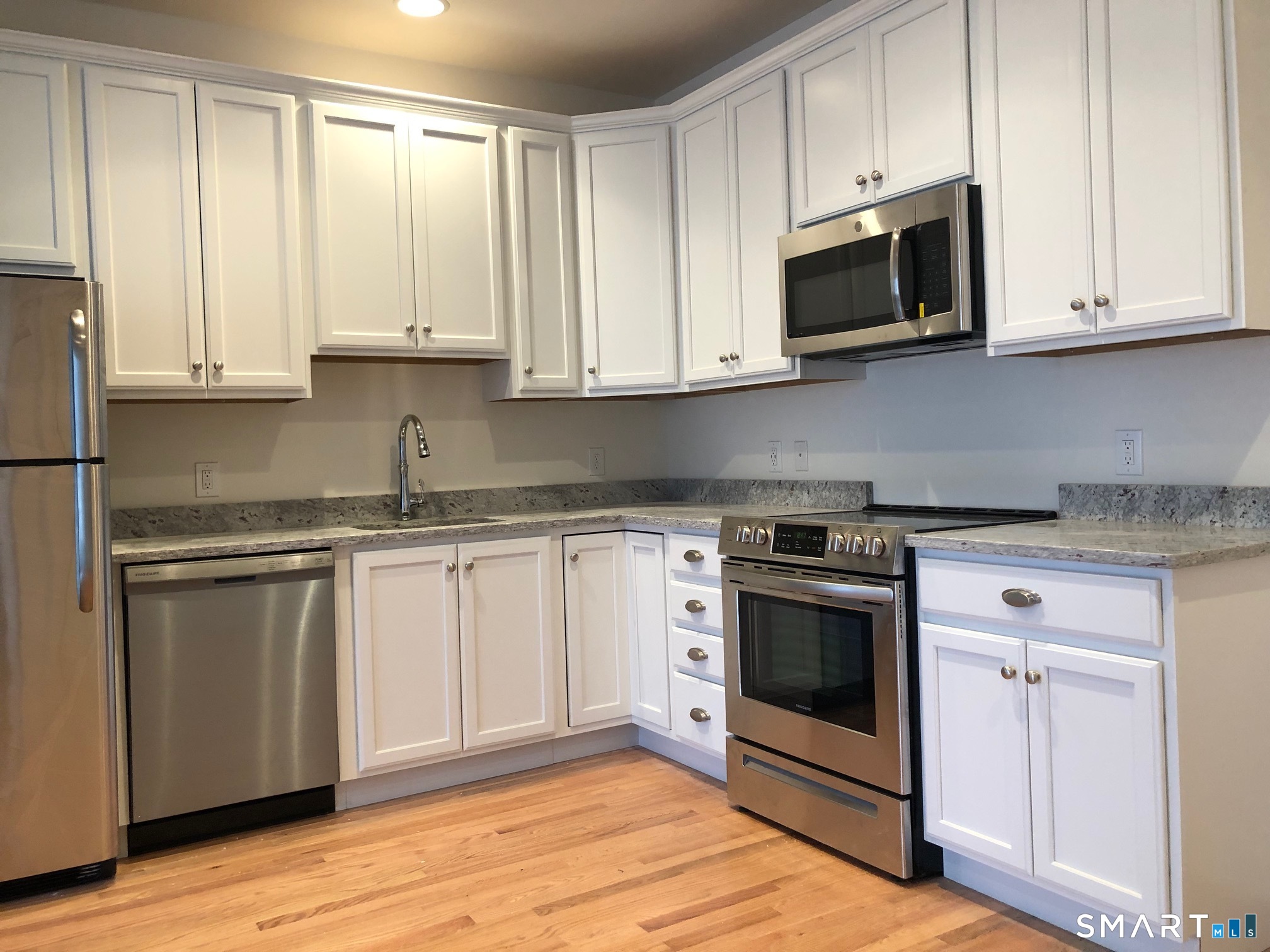 35 Old Quarry Road, Unit C8 Ridgefield, CT 06877 - Photo 4 of 15 a kitchen with stainless steel appliances granite countertop a stove a sink and a microwave