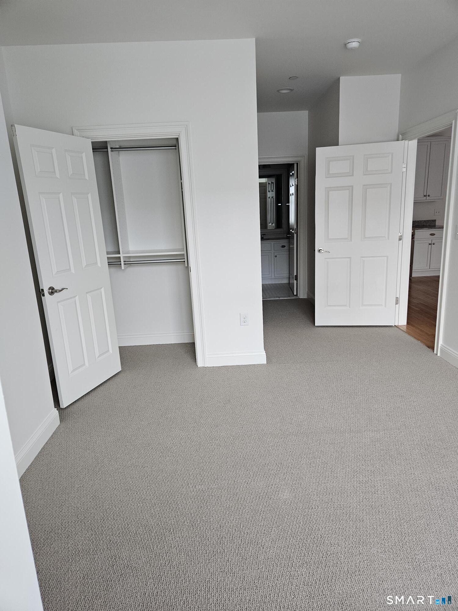 35 Old Quarry Road, Unit C8 Ridgefield, CT 06877 - Photo 7 of 15 an empty room with a mirror and a kitchen view