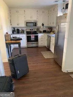 a kitchen with stainless steel appliances granite countertop a refrigerator a stove top oven a sink and dishwasher