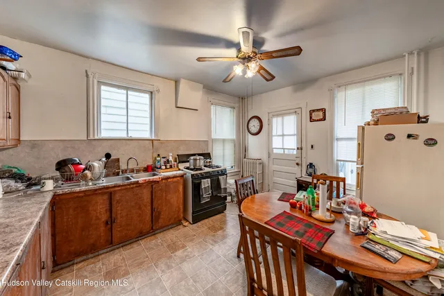 a kitchen with stainless steel appliances a table chairs and a refrigerator
