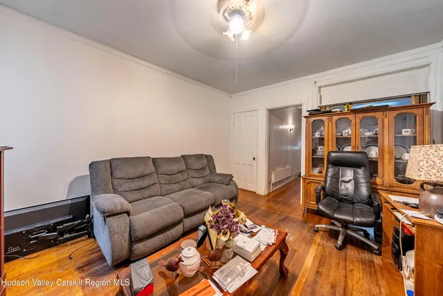 a living room with furniture a flat screen tv and a dining table
