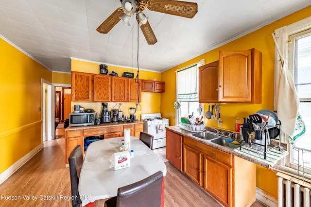 a kitchen with stainless steel appliances a sink a stove a refrigerator cabinets and a large window