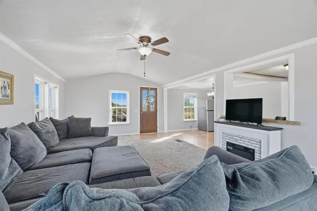 a living room with furniture a flat screen tv and a fireplace