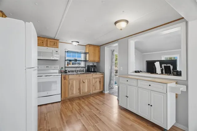 a kitchen with granite countertop white cabinets and white appliances