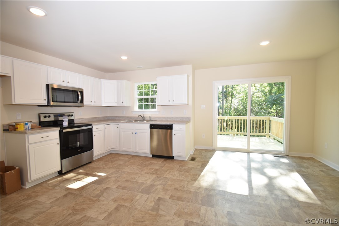 2435 Meadow Road Sandston, VA 23150 - Photo 2 of 14 a kitchen with granite countertop a stove top oven sink and cabinets