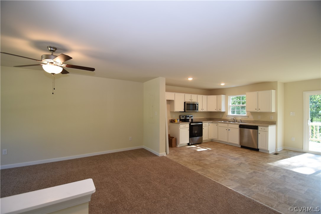 2435 Meadow Road Sandston, VA 23150 - Photo 7 of 14 a open kitchen with a refrigerator a sink dishwasher with a dining table and chairs