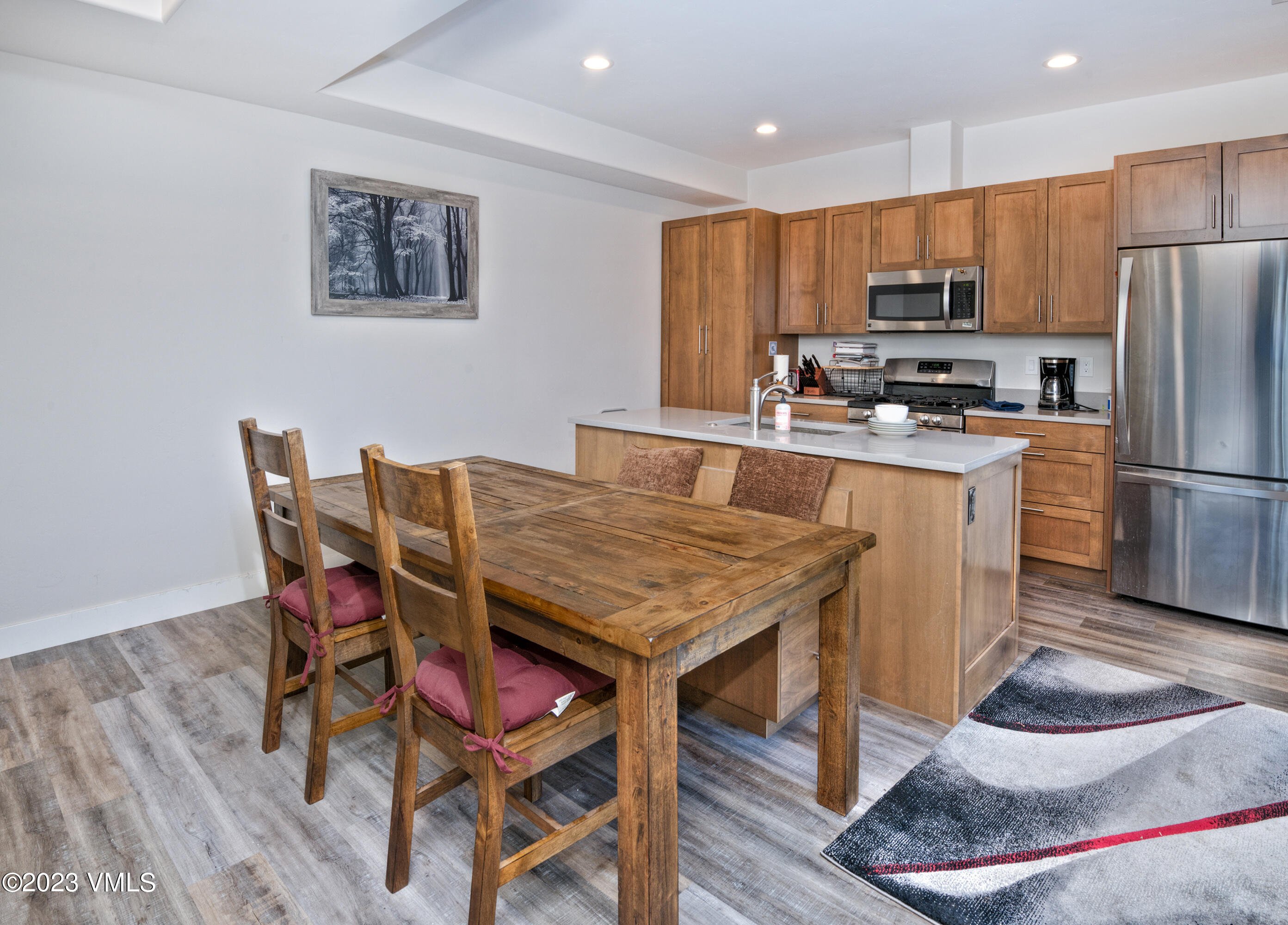 316 Wall Street, Unit 8 Eagle, CO 81631 - Photo 5 of 19 a kitchen with stainless steel appliances granite countertop a stove a refrigerator a kitchen island and chairs