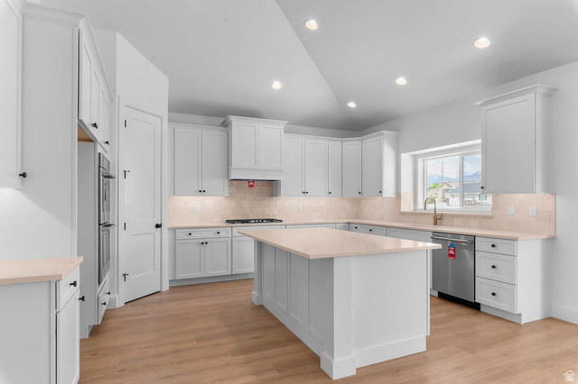 11711 South Halls Crk Road Draper, UT 84020 - Photo 15 of 31 Kitchen with vaulted ceiling, light wood-style floors, white cabinets, stainless steel appliances, and a center island
