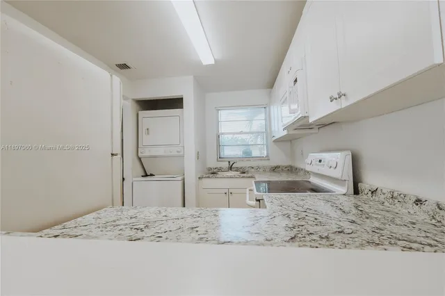 a kitchen with stainless steel appliances kitchen island granite countertop a sink stove and refrigerator