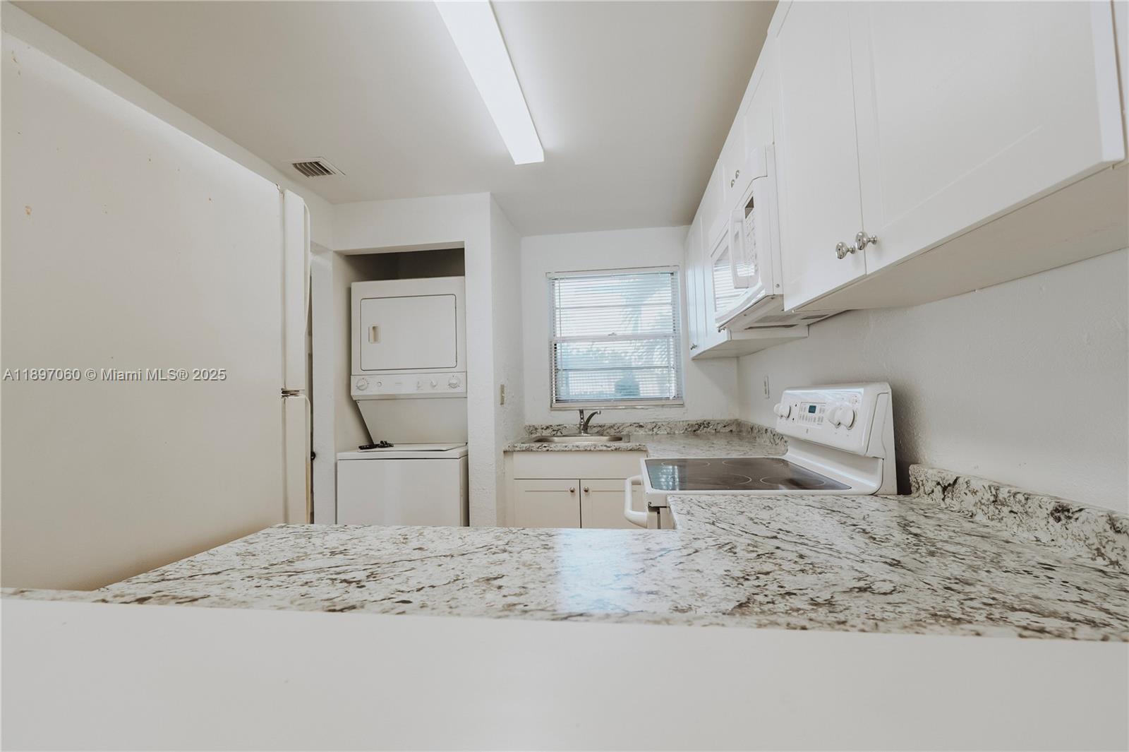 3791 Northwest 78th Avenue, Unit 24 Davie, FL 33024 - Photo 11 of 22 a kitchen with stainless steel appliances kitchen island granite countertop a sink stove and refrigerator