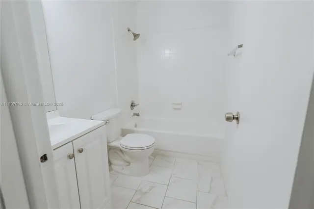 a bathroom with a white toilet and a shower