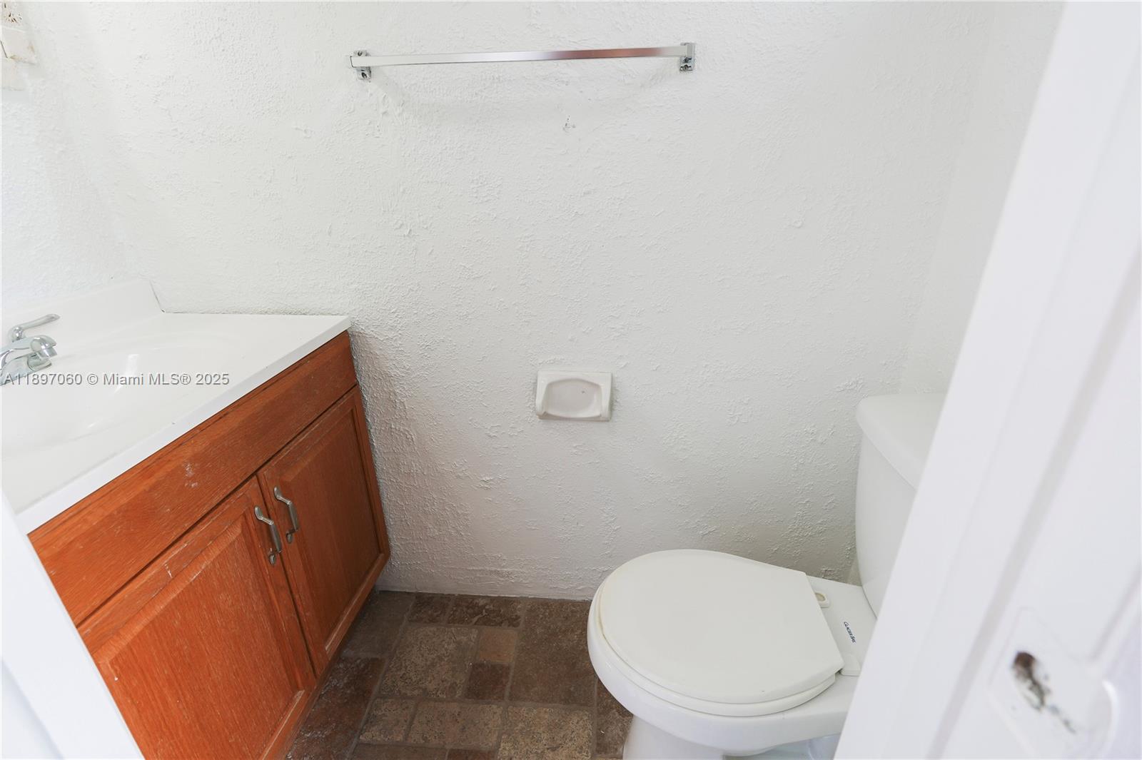 3791 Northwest 78th Avenue, Unit 24 Davie, FL 33024 - Photo 8 of 22 a bathroom with a granite countertop toilet and a sink