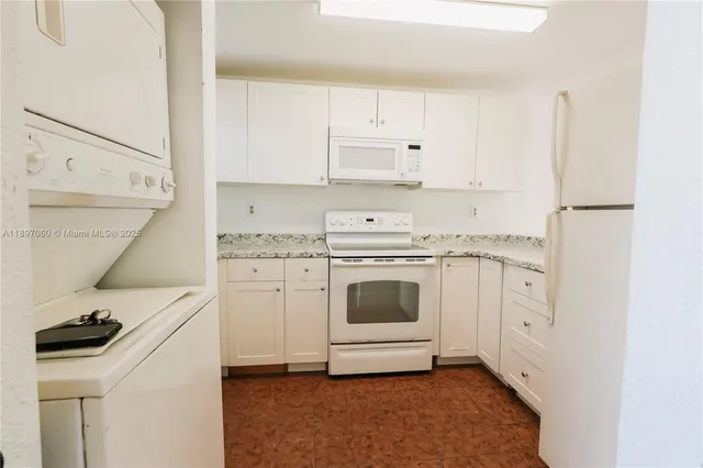 a kitchen with white cabinets and white appliances