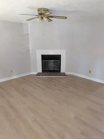 an empty room with a fireplace and a fan