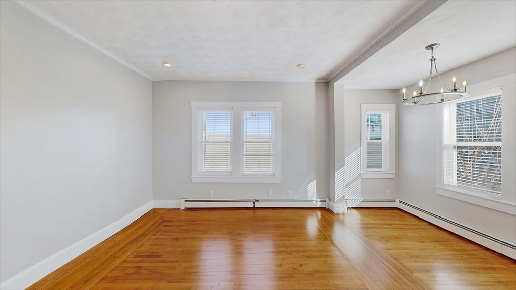 40-42 Upham Street, Unit 1 Malden, MA 02148 - Photo 4 of 17 an empty room with wooden floor and windows