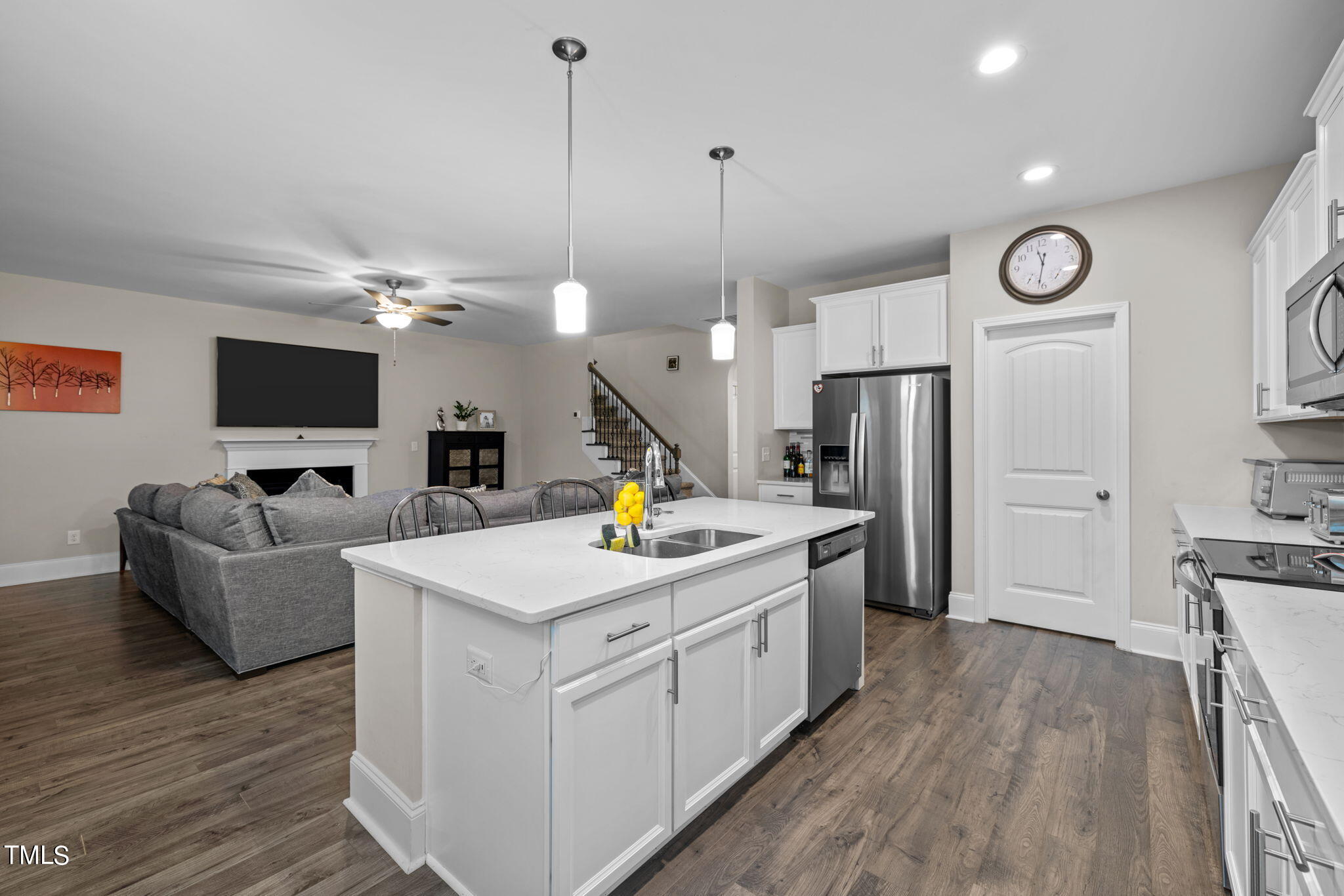 901 Peterson Ridge Road Fuquay-Varina, NC 27526 - Photo 9 of 23 a kitchen with stainless steel appliances granite countertop a sink dishwasher a refrigerator and a fireplace with wooden floor