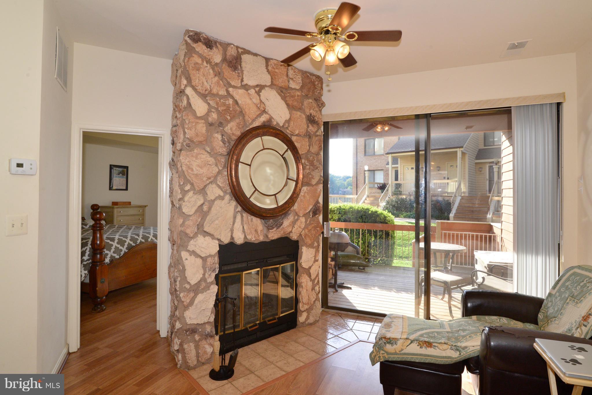 11220 Harbor Court, Unit 11220 Reston, VA 20191 - Photo 13 of 29 Living Room with ceiling fan and fireplace.