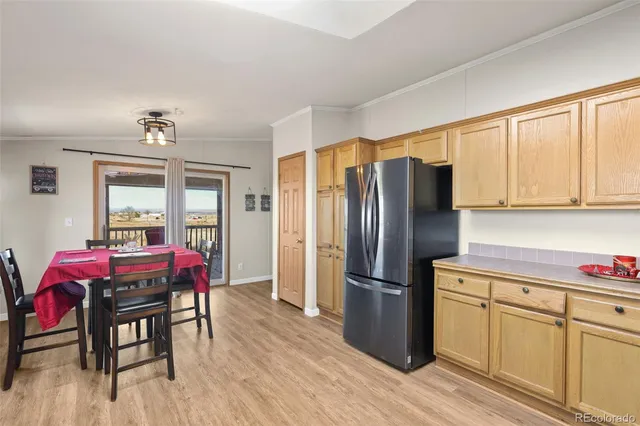 a kitchen with granite countertop wooden floors stainless steel appliances and dining table