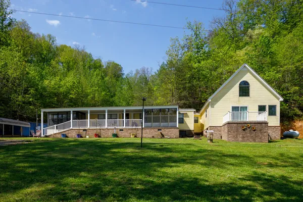 a front view of a house with a yard and green space